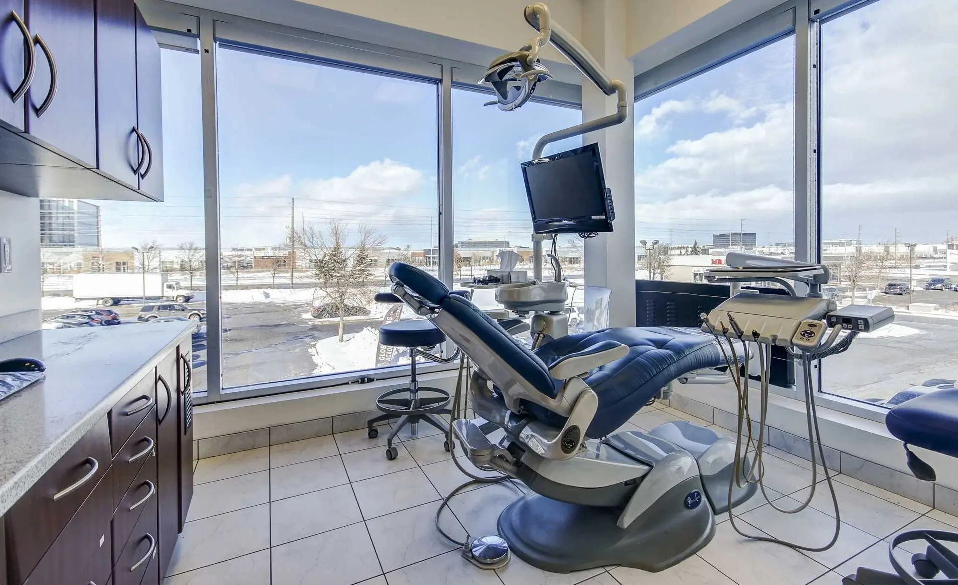 Treatment room at Sunrise Dentistry with a dental chair beside floor-to-ceiling windows