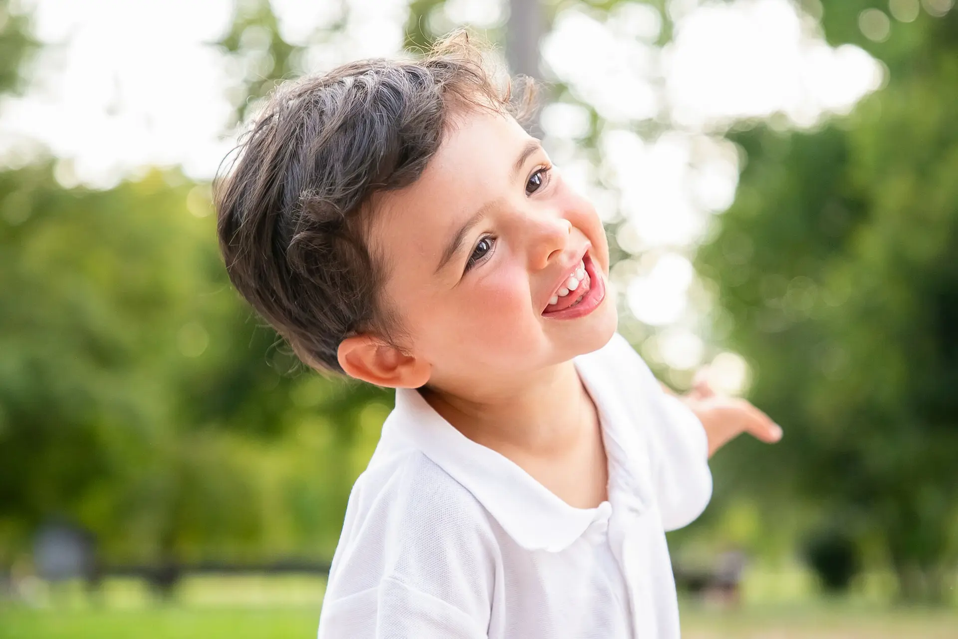 A young boy laughing in a park