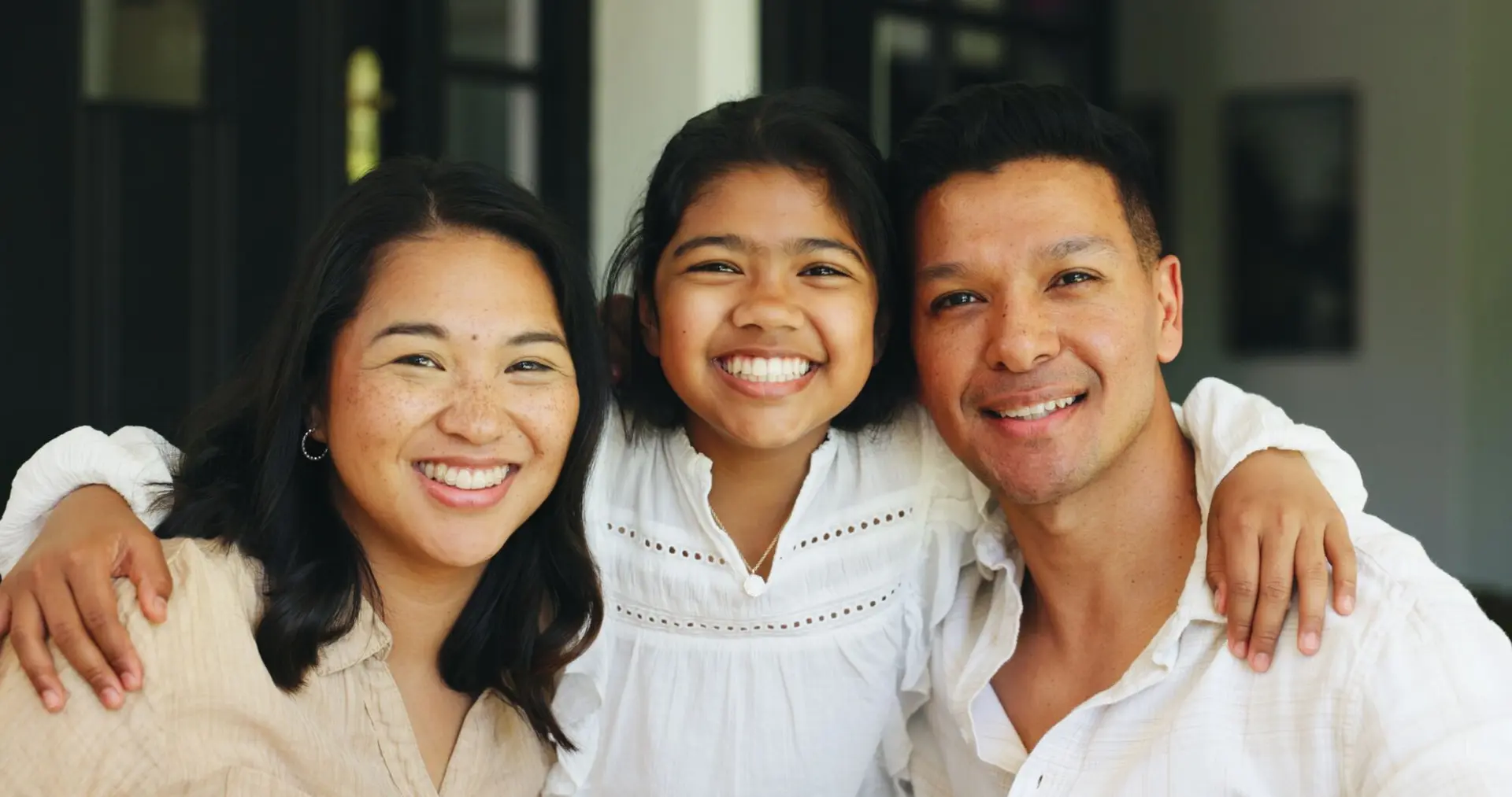 Parents and their daughter smiling together