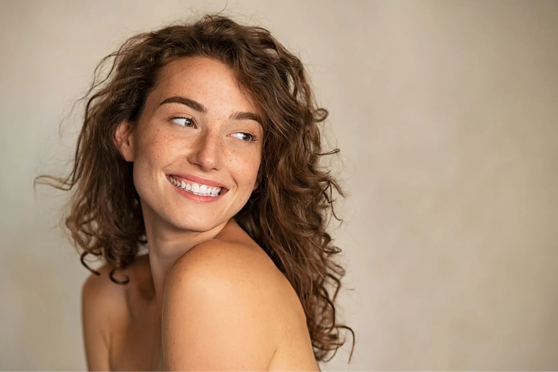 A woman with curly hair and a bright smile