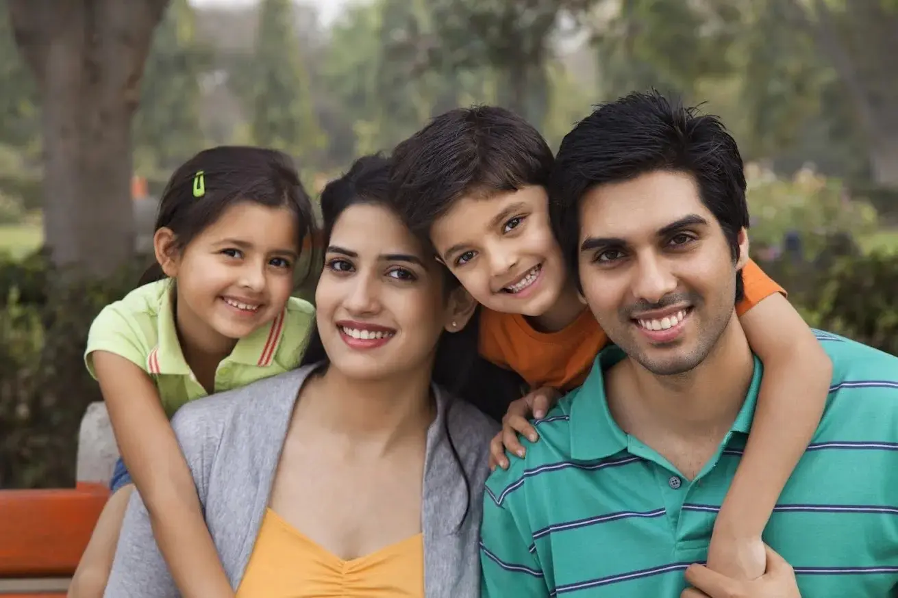 A smiling family of four outdoors