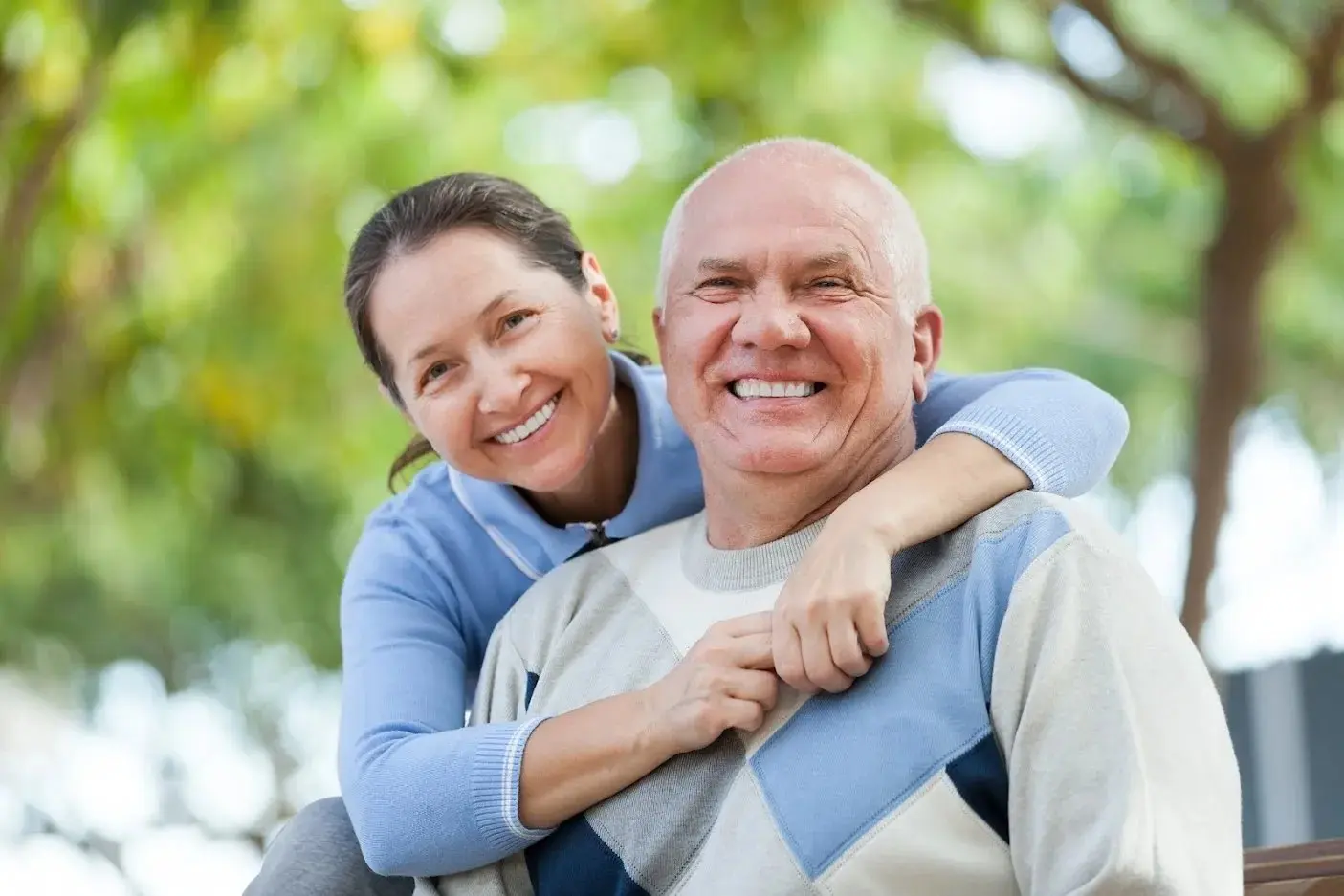 An older couple smiling together in a park